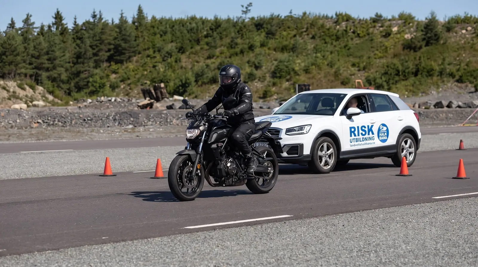 Illustration: motorcyklist och utbildningsbil på halkbanan
