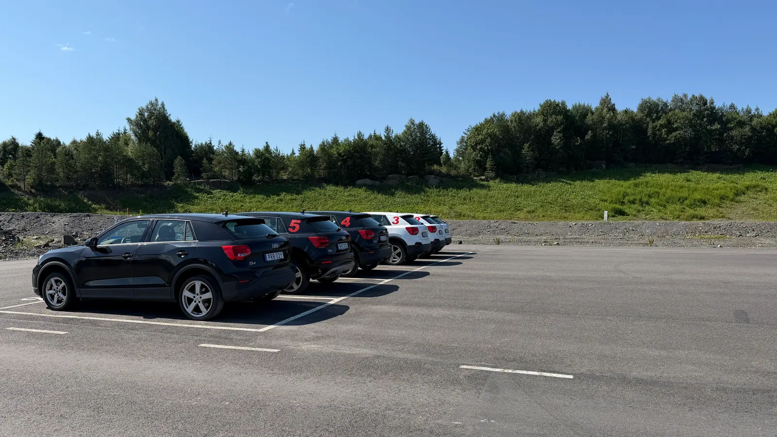 Utbildningsbilar på parkeringen vid halkbanan